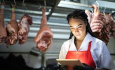 woman using an app in a meat room