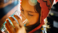 child drinking from cup