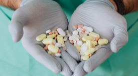 doctor's gloved hands holding antibiotics