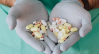 doctor's gloved hands holding antibiotics