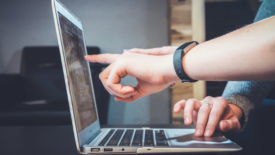 people pointing at laptop screen