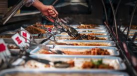 person using tongs at a buffet