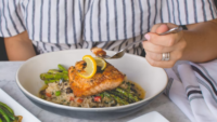 someone lowering their fork into a plate of freshwater fish