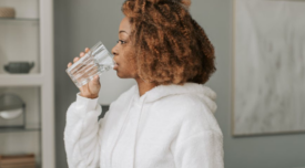 woman drinking water out of a glass