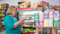 woman looking at product label in grocery store