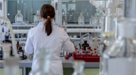 woman with back turned to camera conducting tests in a lab