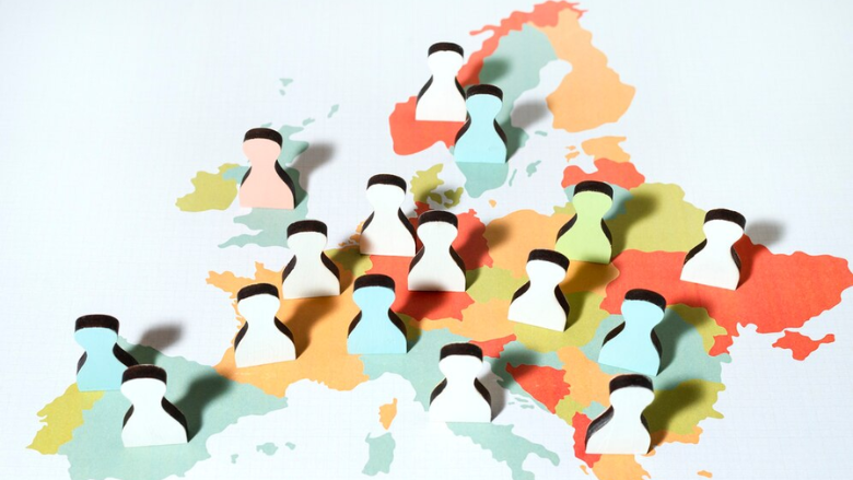 3D paper art of Europe map with cut-out silhouettes of people placed across the map