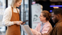 a waiter talking to a customer holding a menu