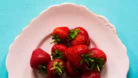 aerial view of plate of strawberries on blue table