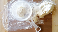 flour in a sifter on wood surface