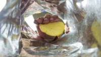 hand pulling potato chip out of bag