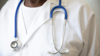 man in white coat with stethoscope around neck