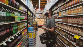 man wearing mask looking at grocery shelves