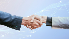 men's hands in suits shaking hands connected datapoints in background