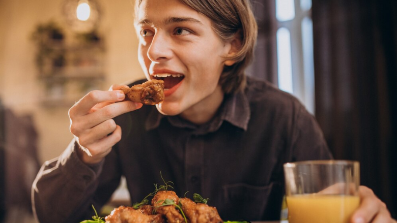 person eating fried chicken wing