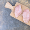 raw chicken breast on wooden board