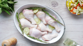 raw chicken drumstick in bowl on table 