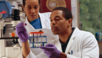 two lab techs looking at test tubes