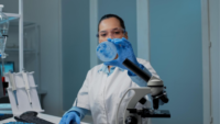 woman in lab looking at petri dish