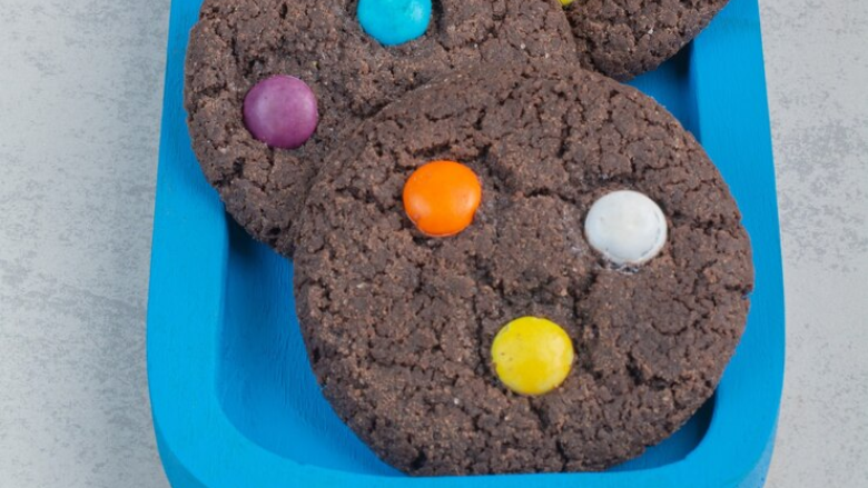 chocolate cookies with colorful candies in them sitting on a tray