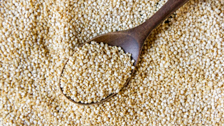 dry quinoa and a wooden spoon