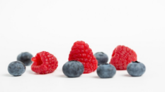 fresh raspberries and blueberries on white background