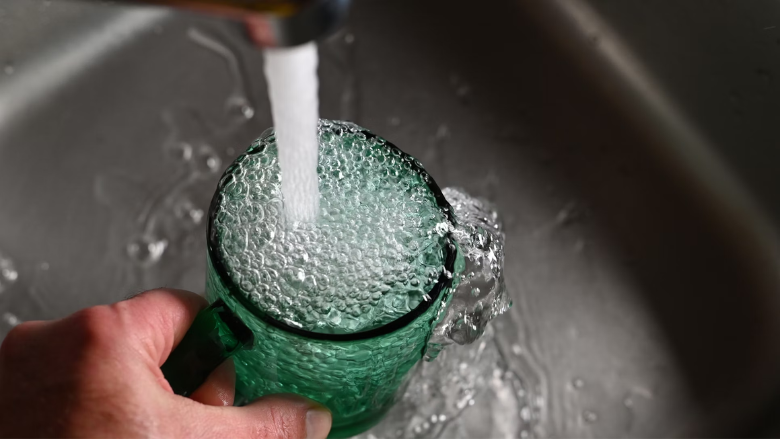 glass of tap water getting filled in the kitchen sink