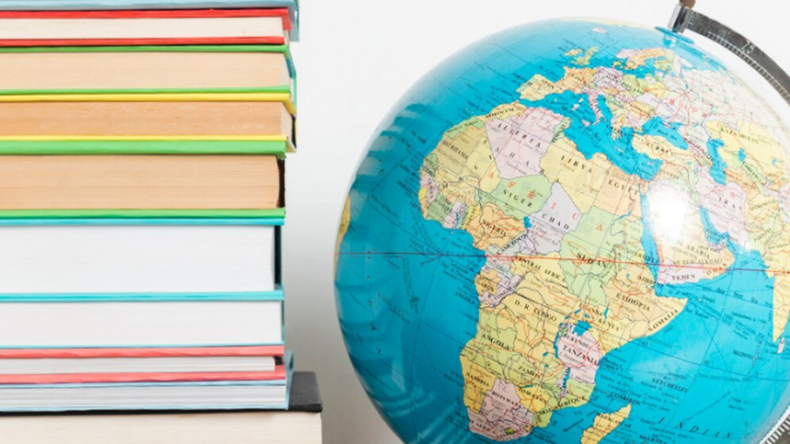 pile of books next to globe showing near east and north africa