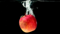 whole red apple dropped into water