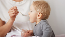 baby being spoon-fed jarred baby food