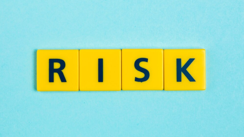 yellow letter tiles on blue background that spell 'risk'