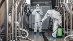 men in hazmat suits cleaning plant