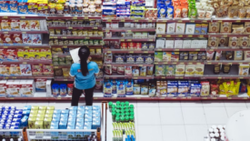 woman checking grocery store shelves