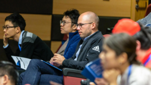 adults in a lecture hall listening attentively